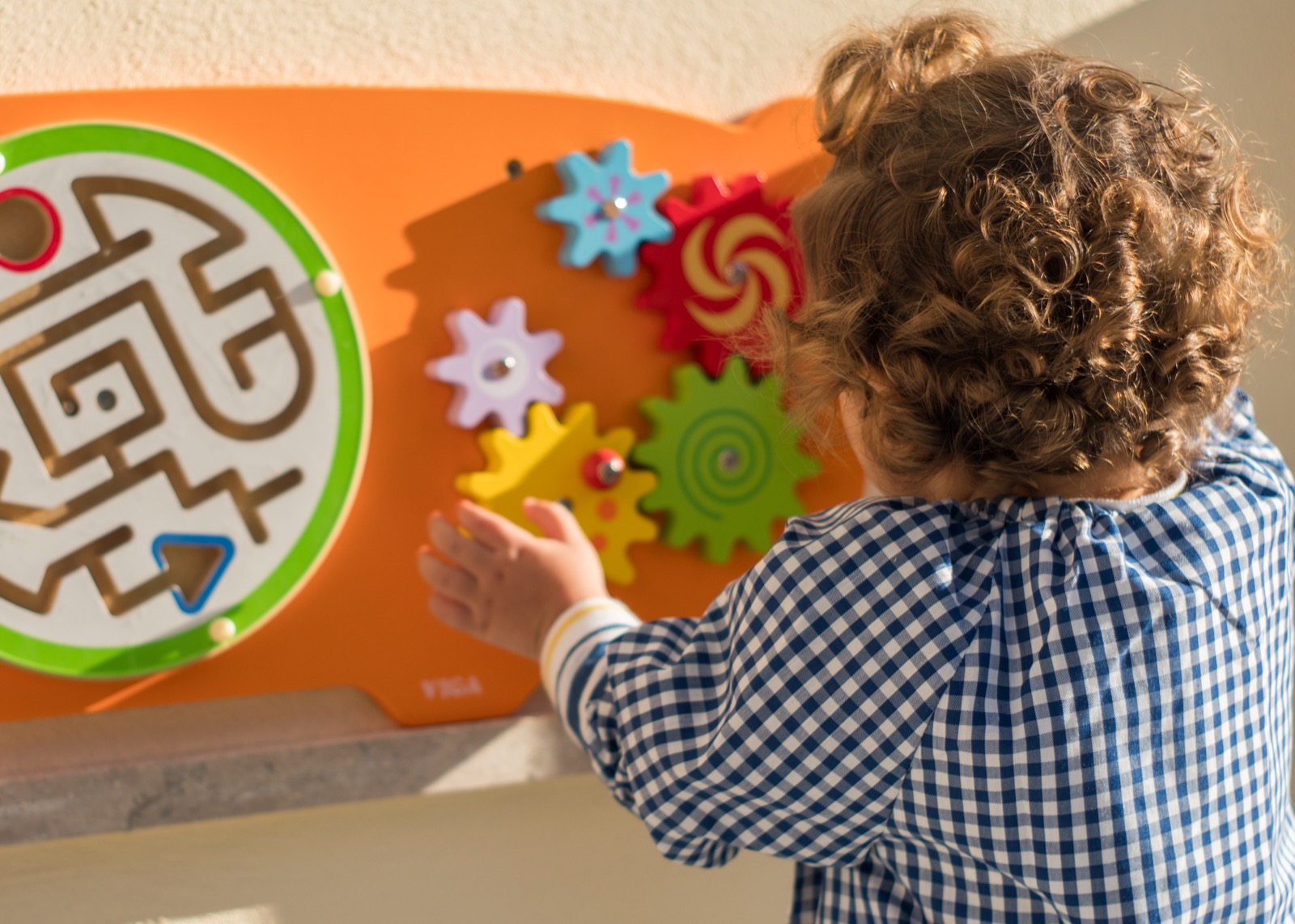 Alumno de la Escoleta explorando un panel sensorial de engranajes